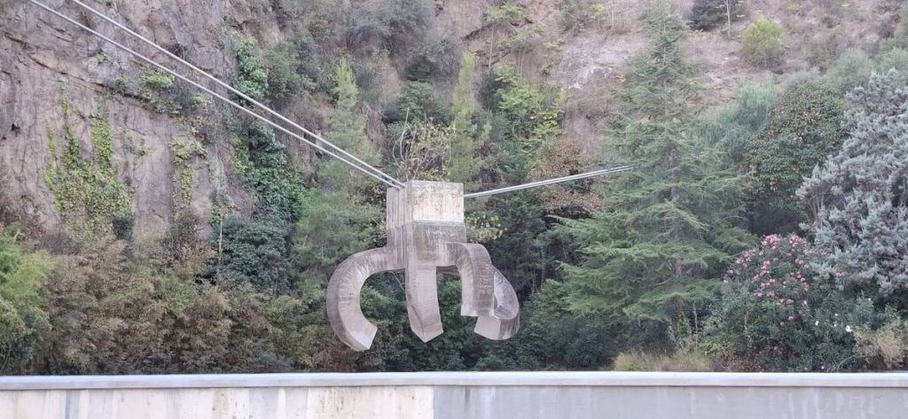 Escultura Elogio del Agua de Eduardo Chillida suspendida frente a la pared de la antigua cantera